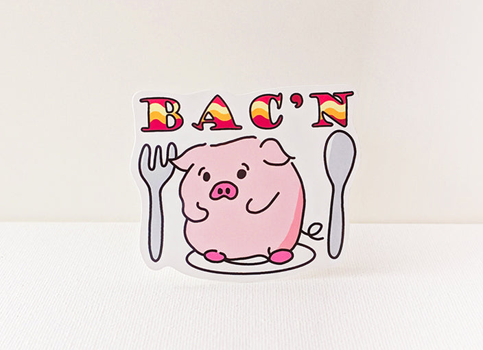 Cartoon pig holding utensils with 'BAC'N' text on a white background
